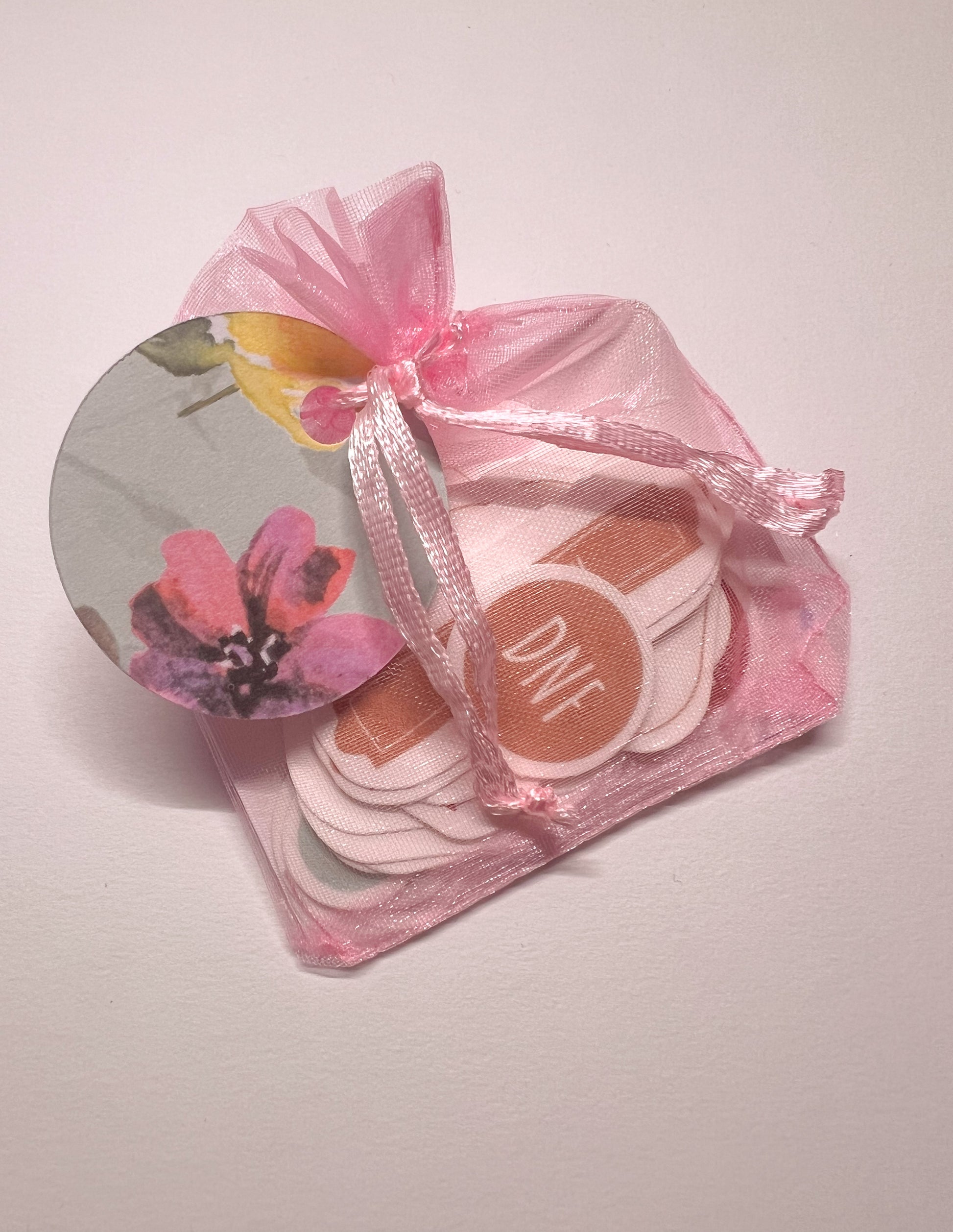 Pink decorative bag with book inspired stickers on a light background
